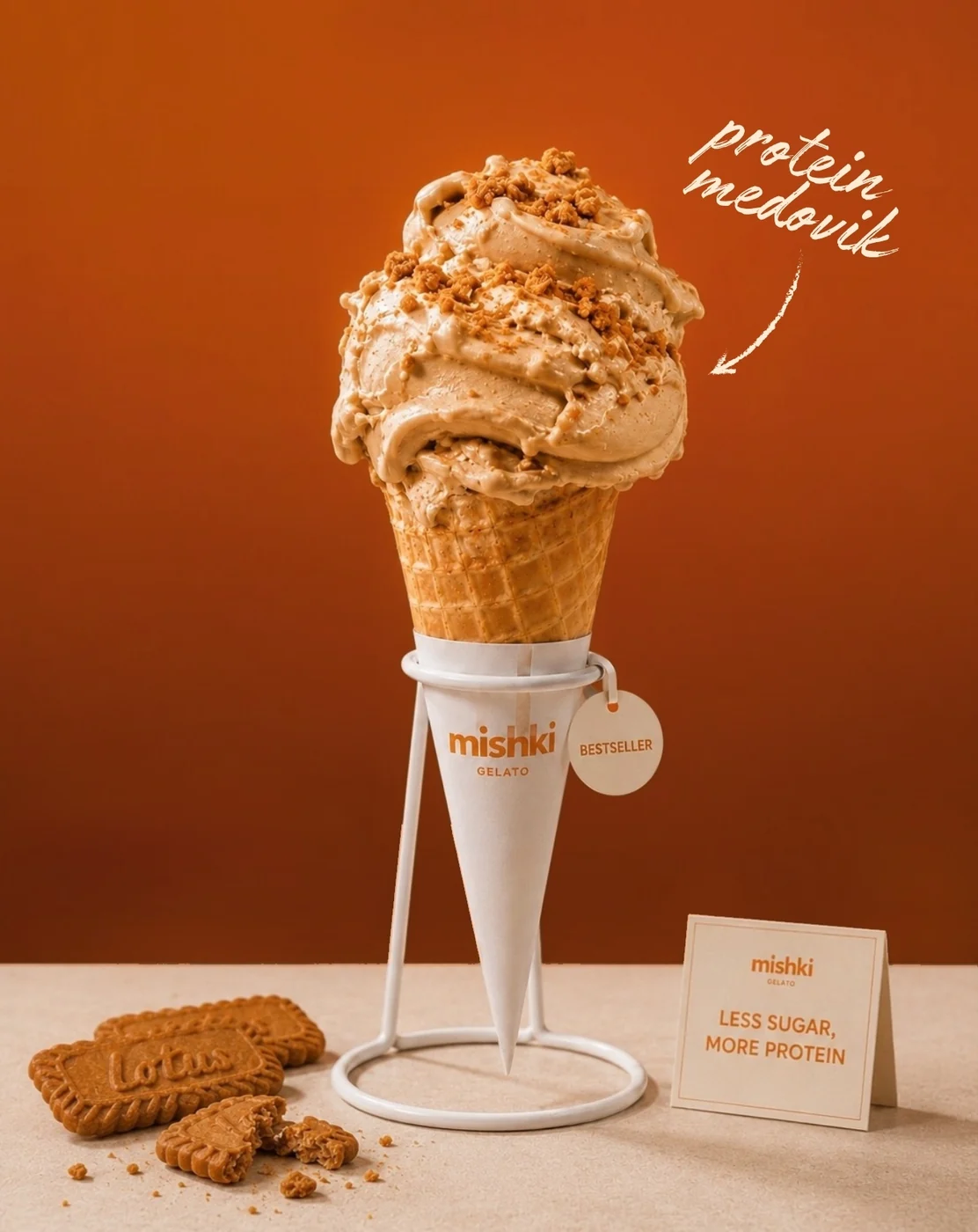 A cone of Protein Medovik gelato with biscotto crumbs on a white Mishki cone stand
