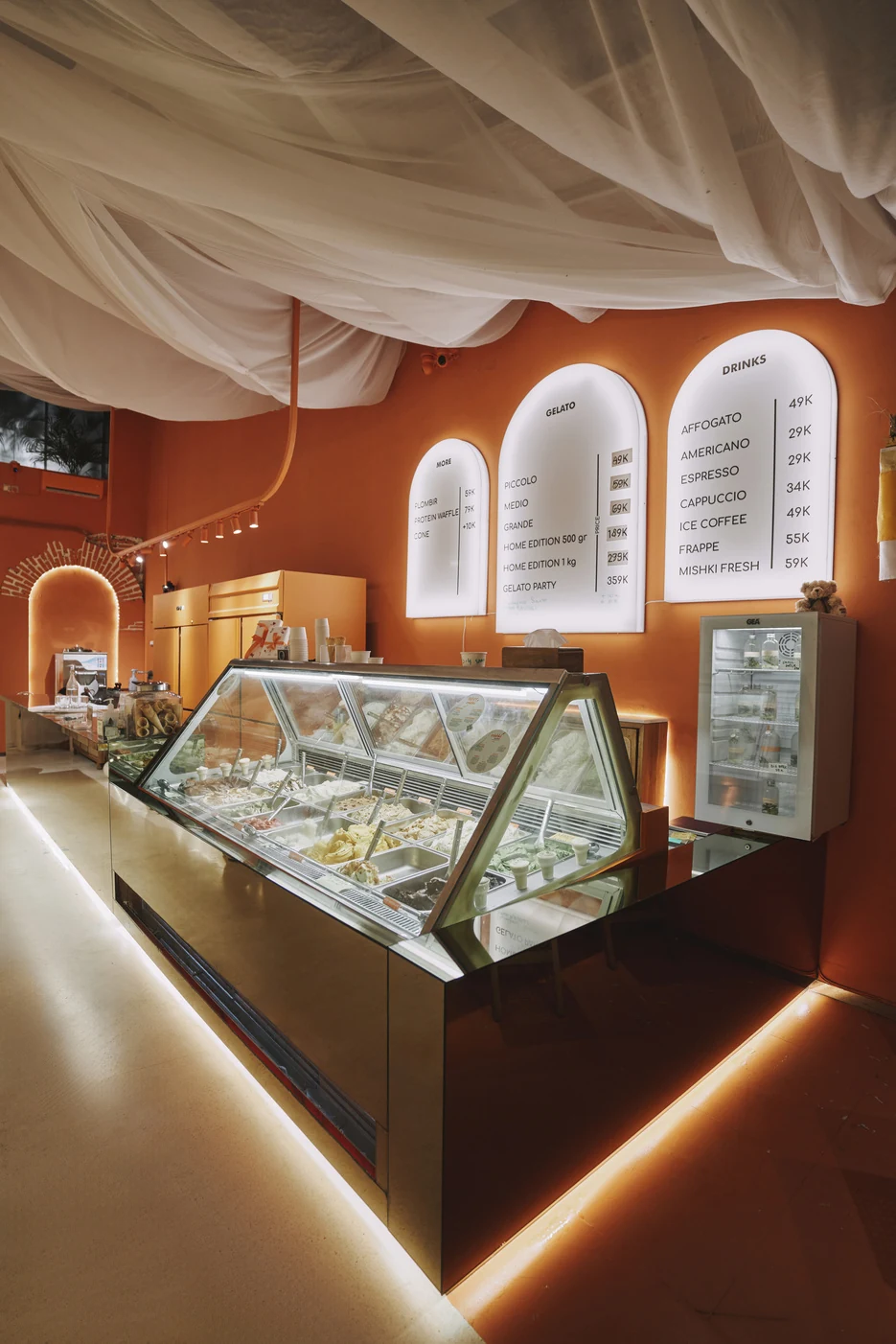 The Mishki gelato display under glowing arched menu boards